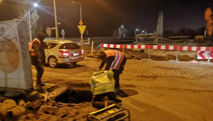 Robotnicy stoją przy zapadniętej studzience teletechnicznej 