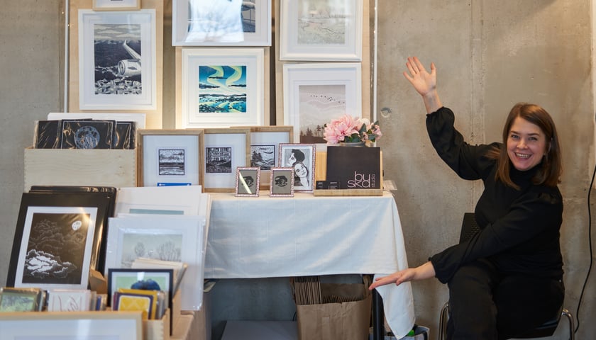 Na zdjęciu widać sprzedawczynię, która prezentuje rzeczy, które sprzedaje na targach 