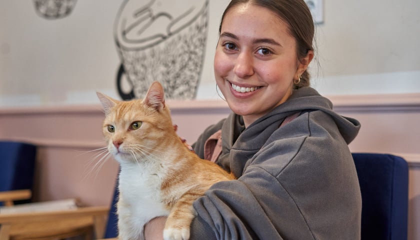 Ola, która pracuje w Kot Cafe na Nadodrzu oraz jeden z kotów z tej kawiarni