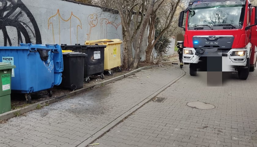 Na zdjęciu: pojemniki na odpady i wóz strażacki