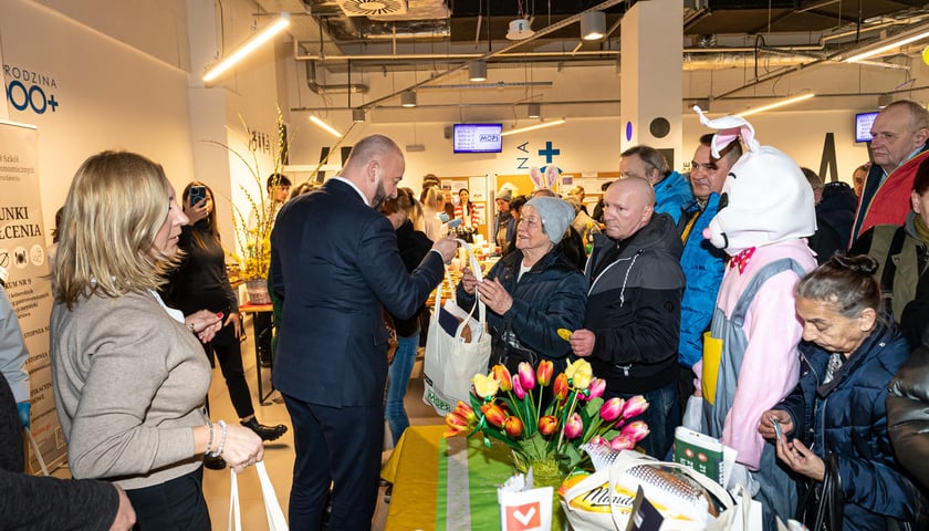 Na zdjęciu prezydent Wrocławia Jacek Sutryk rozdaje paczki klientom Miejskiego Ośrodka Pomocy Społecznej