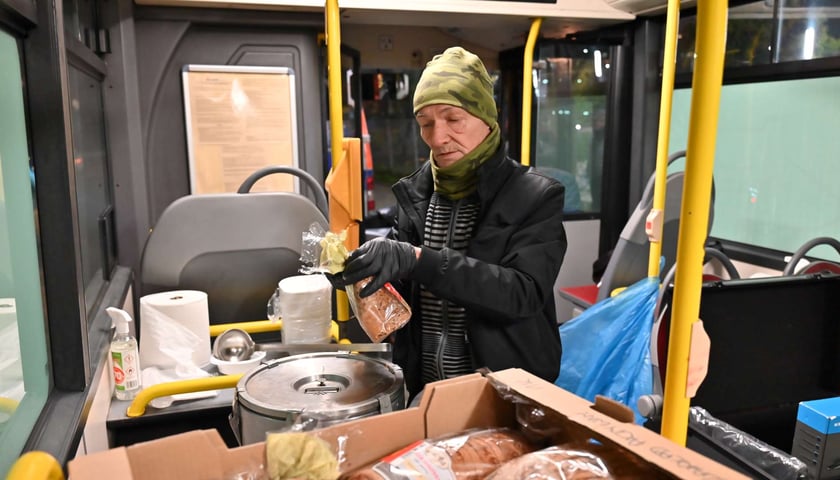 Osoby z fundacji Homo Sacer każdego dnia wydawały pasażerom Streetbusa średnio po 250 posiłków dziennie. Na zdjęciu jeden z wolontariuszy częstuje chlebem do zupy.