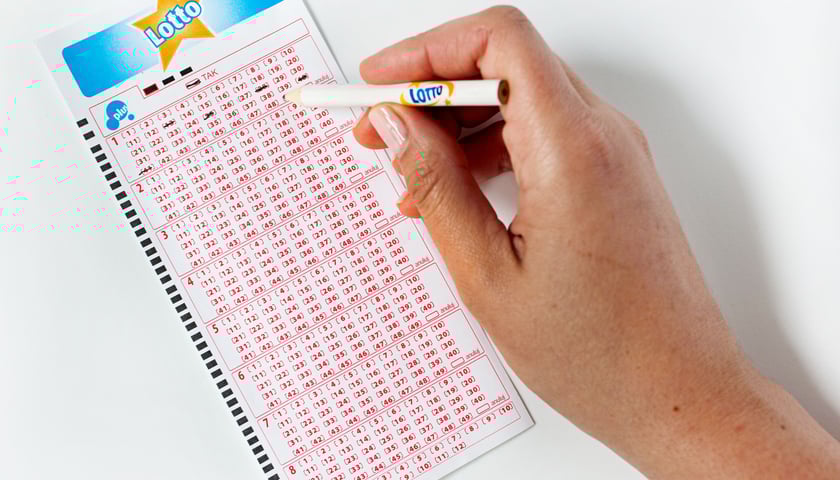 Kupon Lotto. Na zdjęciu widać, jak ktoś skreśla cyfry na kuponie