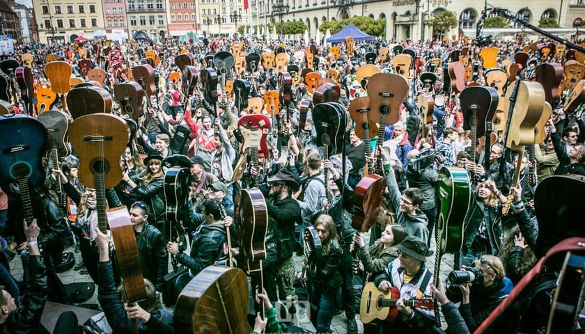 Uczestnicy Gitarowego Rekordy Świata z uniesionymi nad głowę instrumentami