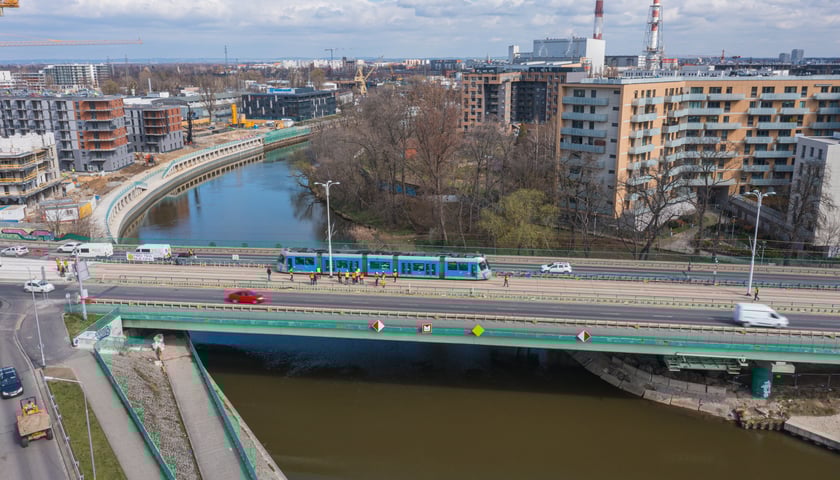 Na zdjęciu most Dmowskiego z lotu drona z niebieskim tramwajem podczas prób obciążeniowych