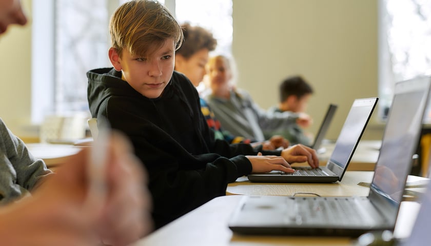 Uczniowie pracują przy laptopach (zdjęcie ilustracyjne)