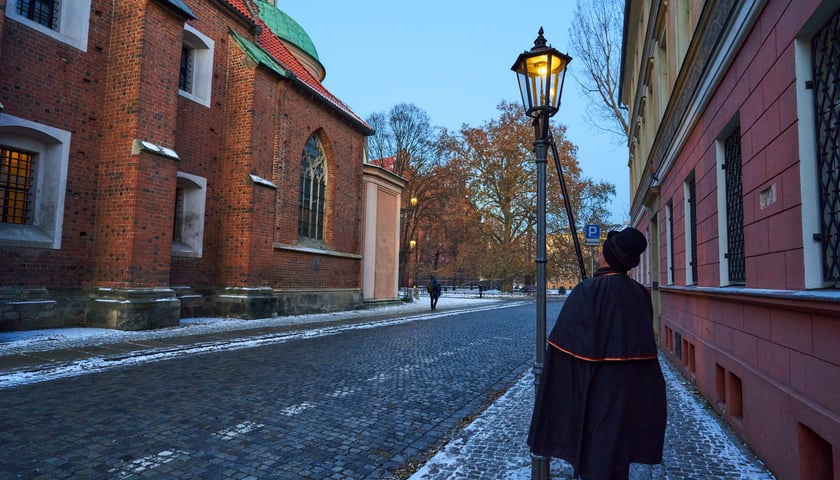 Latarnik każdego wieczora we Wrocławiu zapala na Ostrowie Tumskim latarnie.