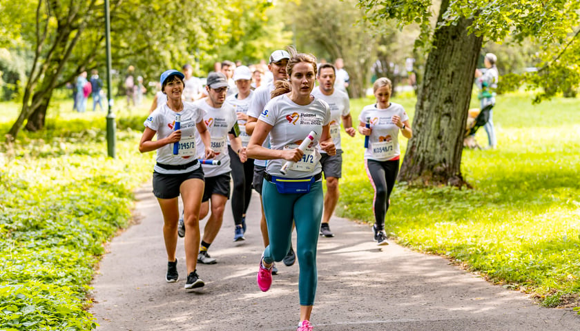 Grupa biegaczy na trasie Poland Business Run w parku we Wrocławiu