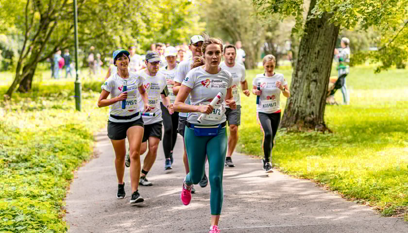 Grupa biegaczy na trasie Poland Business Run w parku we Wrocławiu