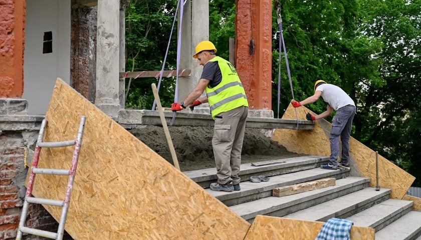 Pracownicy układają schody na terenie Bastionu Sakwowego. Na zdjęciu widzimy dwóch mężczyzn podczas prac