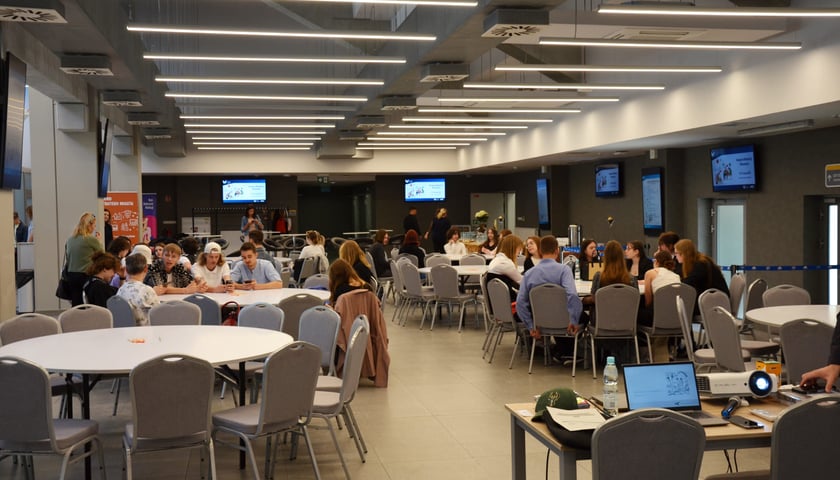 Kongres Młodzieży Wrocławia, Stadion Olimpijski, 30.05.2023. Na zdjęciu młodzi ludzie siedzący przy okrągłych stołach w sali konferencyjnej.