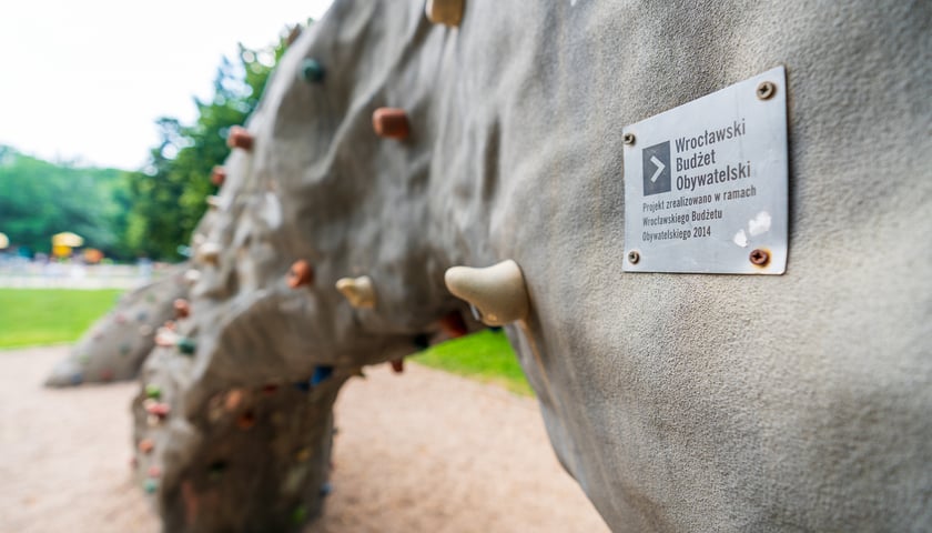 Bezobsługowa ścianka wspinaczkowa z funduszy WBO, na niej przytwierdzona plakietka WBO