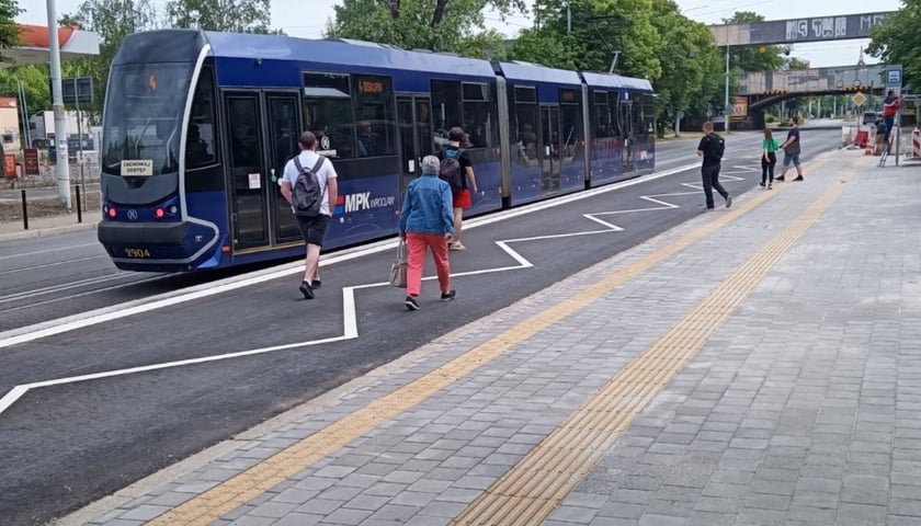 Przystanek wiedeński w ul. Grabiszyńskiej, w tle tramwaj i pasażerowie