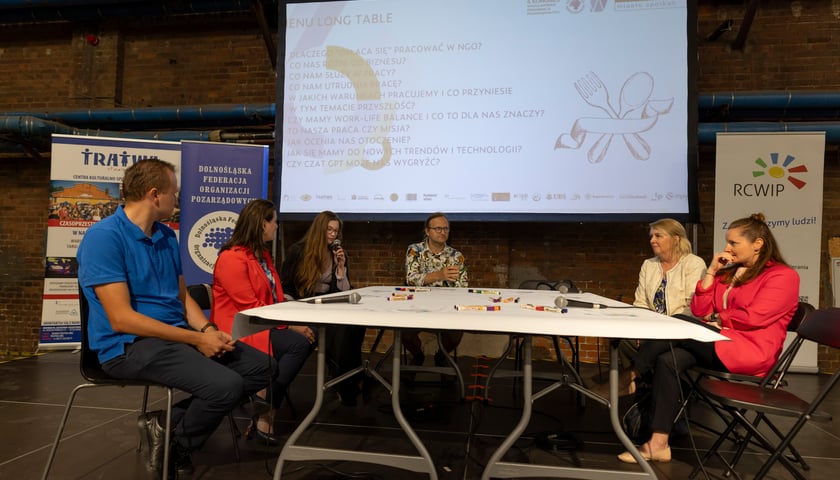 Long table przy kt&oacute;rym uczestnicy dyskutują o ngo-sach jako pracodawcach przyszłości