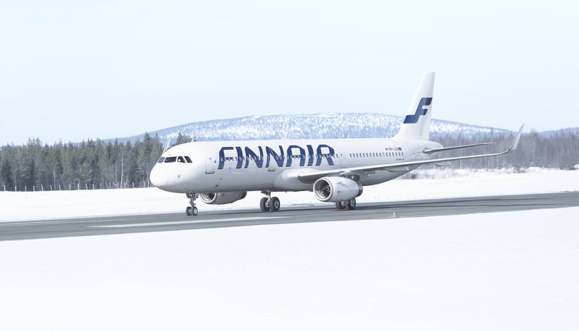 Biały samolot Finnair stojący w zimowej scenerii Finlandii