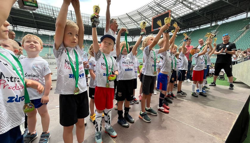 Młodzi piłkarze wznoszą puchar za wygraną w Mistrzostwach Świata Przedszkolaków na Tarczyński Arenie Wrocław