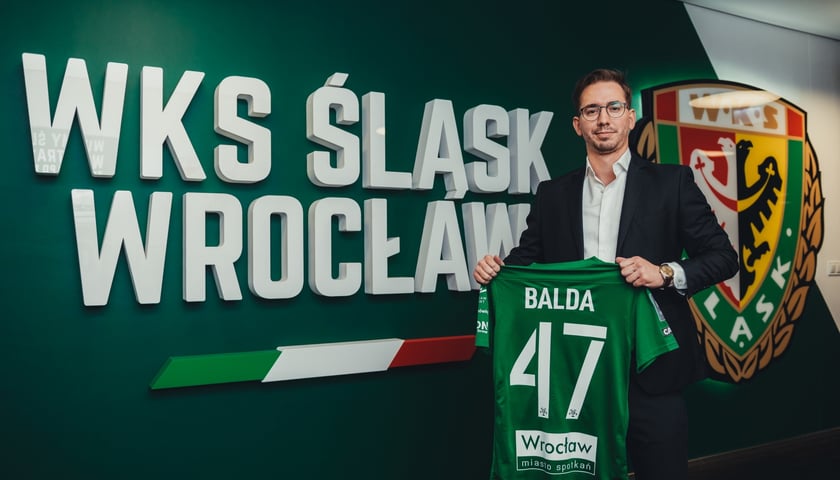 David Balda, nowy dyrektor sportowy WKS-u Śląska Wrocław trzyma koszulkę piłkarskiego Śląska ze swoim nazwiskiem