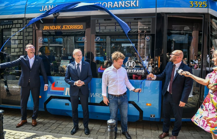 Czterech uśmiechniętych mężczyzn w garniturach stoi przed niebieskim tramwajem, nad nimi powiewa niebieski materiał, który odsłonił napis: Jan Nowak Jeziorański; od lewej Sergiusz Kmiecik, przewodniczący Rady Miejskiej Wrocławia, dr Łukasz Kamiński, dyrektor Zakładu Narodowego Ossolineum, Laurynas Vaičiūnas, prezes zarządu Kolegium Europy Wschodniej, Witold Woźny, prezes MPK Wrocław