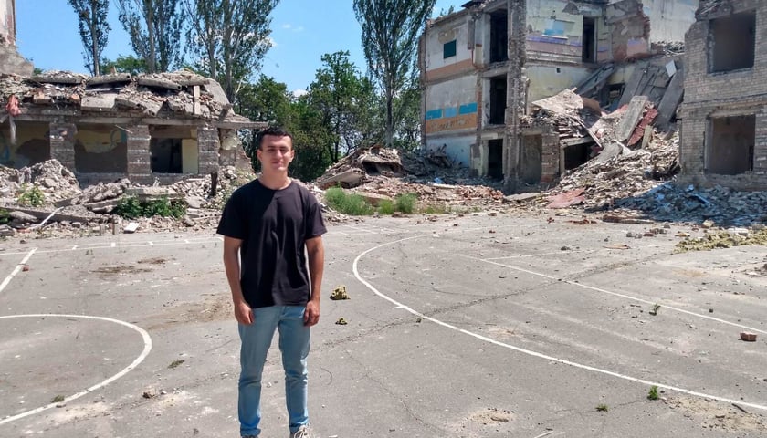 Dima na tle zburzonej przez Rosjan szkoły, do której chodził.