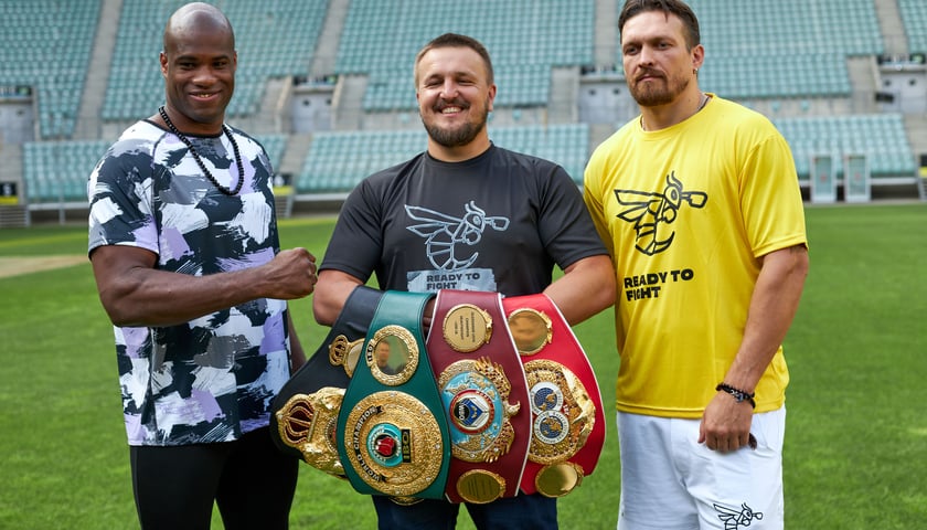 Od lewej: Daniel Dubois,  Oleksander Krassyuk (trzyma cztery pasy mistrzowskie) i Oleksander Usyk na murawie stadionu Tarczyński Arena