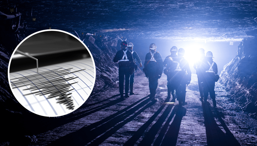 W ciemnym tunelu  w stronę lampy idzie kilkoro górników, widać ich długie cienie i odblaski