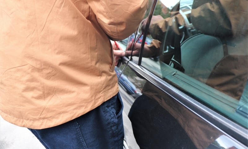 Mężczyzna włamujący się do samochodu / zdjęcie ilustracyjne