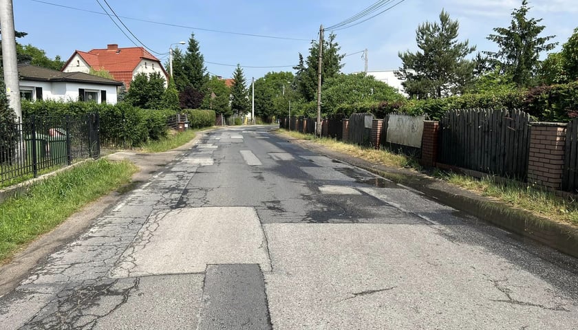 Połatana jezdnia ulicy Wilkszyńskiej na obrzeżach Wrocławia