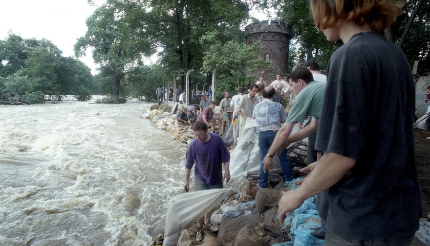 <p>Obrona wrocławskiego zoo podczas powodzi tysiąclecia. Mieszkańcy układają worki z piaskiem na wale za Basztą Niedźwiedzi</p>