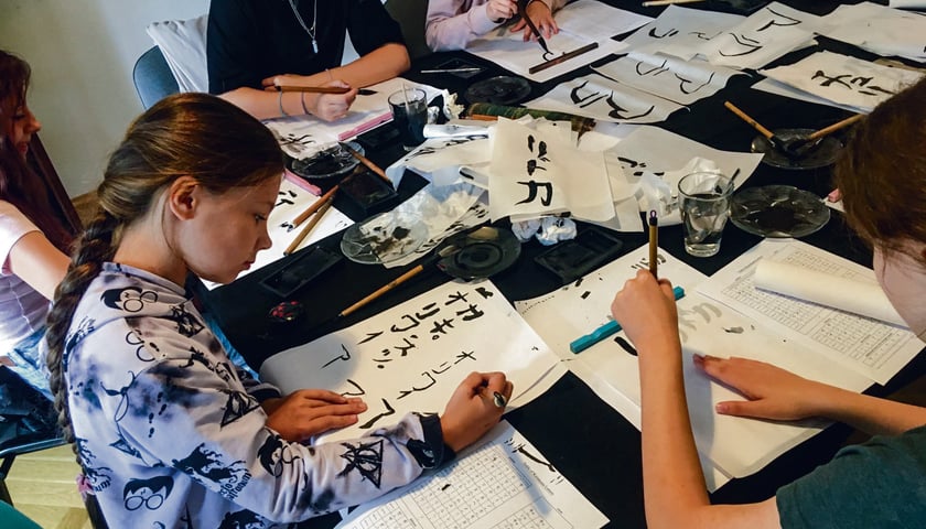 Dzieci podczas zajęć z tradycyjnej japońskiej kaligrafii