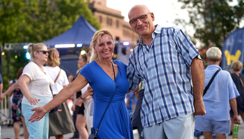 Potańcówka na placu Wolności. Na pierwszym planie para uczestników zabawy - blondynka w niebieskiej sukience i mężczyzna w niebieskiej koszuli w kratę