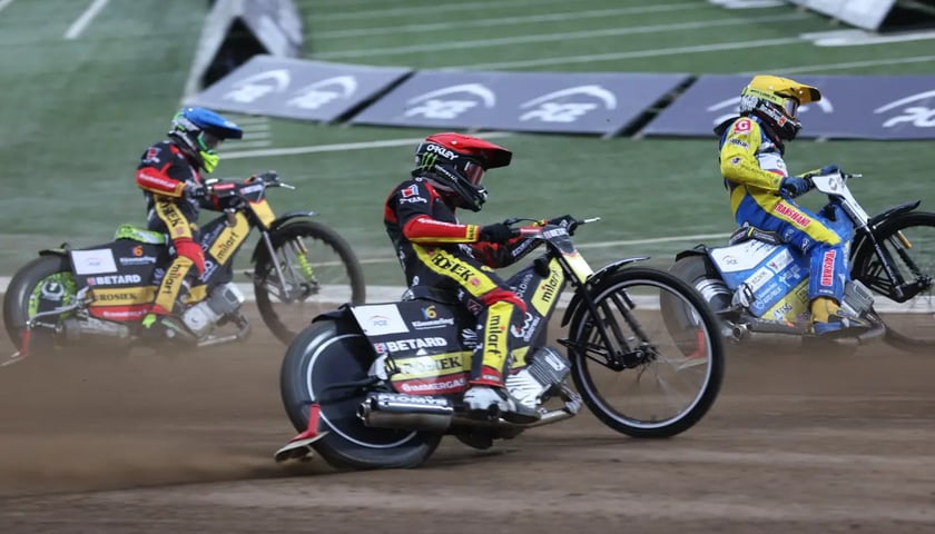 Trzech żużlowców na motocyklach na Stadionie Olimpijskim 