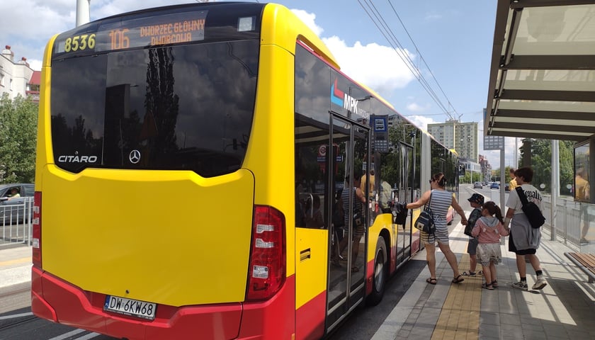 Autobus 106 i czwórka pasażerów przy przystanku Rogowska na nowej trasie autobusowo-tramwajowej (TAT) na Nowy Dwór