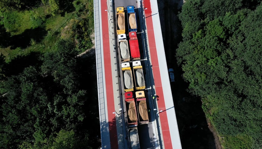 Załadowane ciężarówki na moście Olimpijskim. Testowało go 16 pojazdów ważących po 32 tony.
