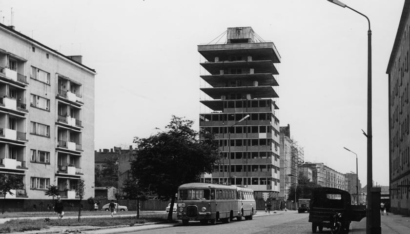 Tak w latach 60. XX w. wyglądała budowa Trzonolinowca przy ul. Kościuszki 72. Widać też autobusy na ulicy oraz okoliczne bloki i latarnie. Czarno-białe zdjęcie z zasobów Muzeum Miejskiego Wrocławia