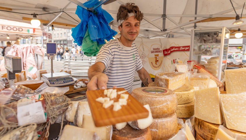 Jarmark włoskich produktów we Wrocławiu, sprzedawca podaje deskę z serem do degustacji.