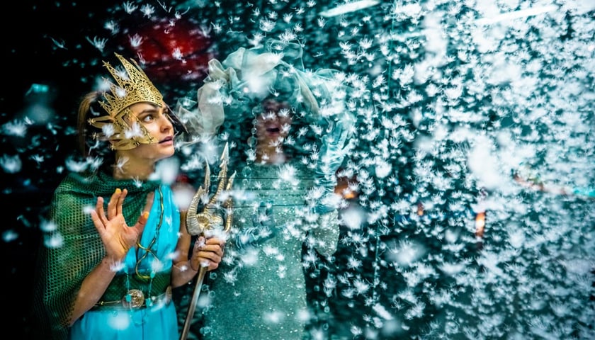 III Letni Festiwal Tajemnic w Zamku Książ. Na zdjęciu widać dwie postaci, jedna z koroną na głowie, w ręce trzyma trójząb. Po prawej stronie zdjęcia widać płatki śniegu 