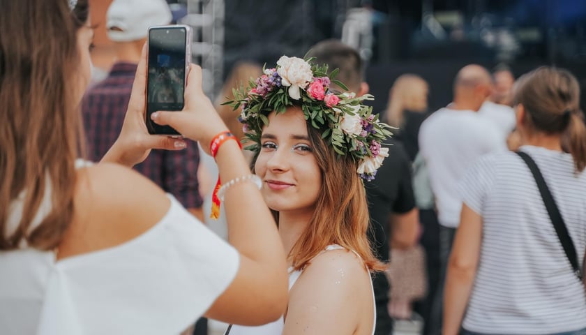 Uśmiechnięta dziewczyna w kwiecistym wianku na koncercie Letnie Brzmienia