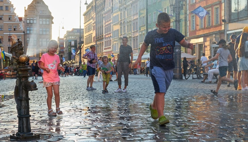 Dzieci w strumieniach wody na rynku we Wrocławiu