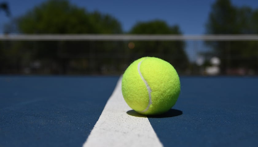 Piłeczka tenisowa na niebieskim korcie, zdjęcie ilustracyjne