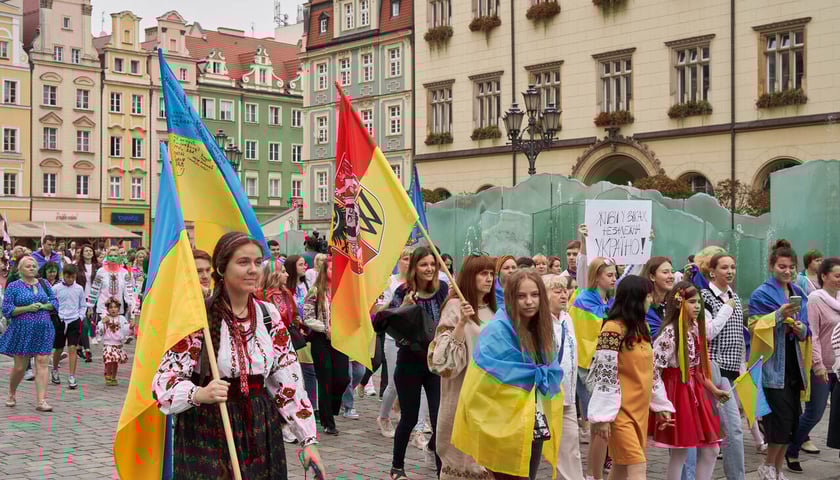 Tłum młodych osób z flagami Ukrainy i Wrocławia