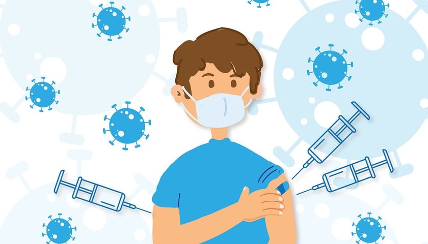 Grafika przedstawia chłopca w maseczce, a dookoła fruwają wirusy i strzykawki