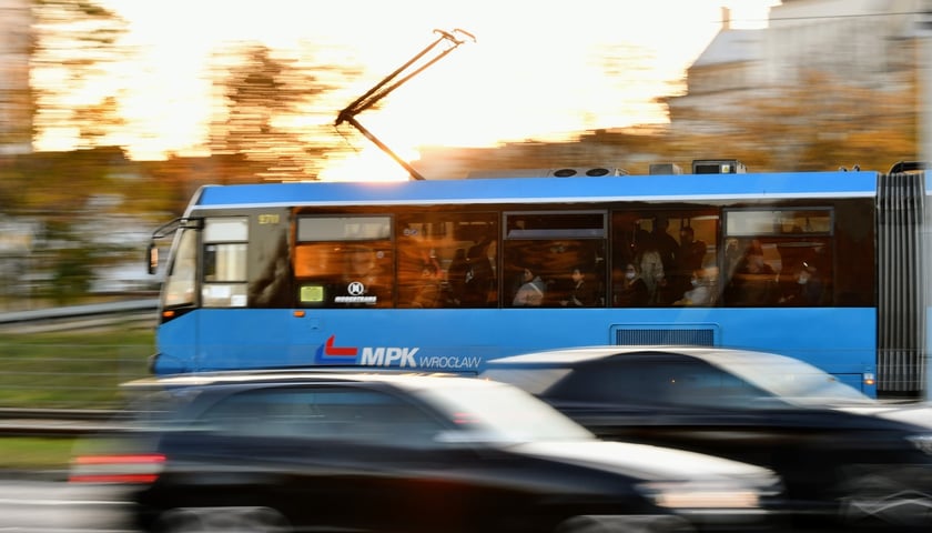 Zdjęcie ilustracyjne przedstawia niebieski tramwaj jadący przez Wrocław. 