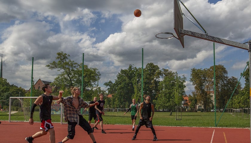 Młodzi mężczyźni grający w koszykówkę na boisku na Karłowicach, wykonanym w ramach WBO. Zdjęcie ilustracyjne