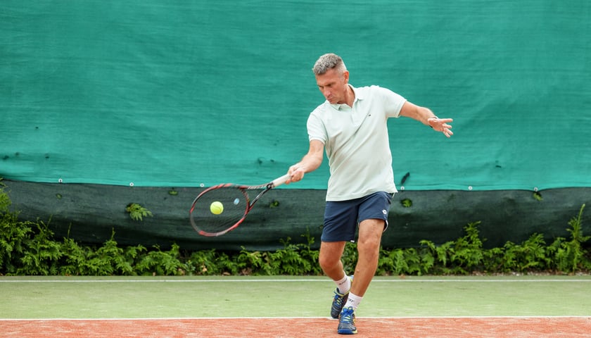 Trener Piotr Sobko na korcie w momencie uderzenia piłki