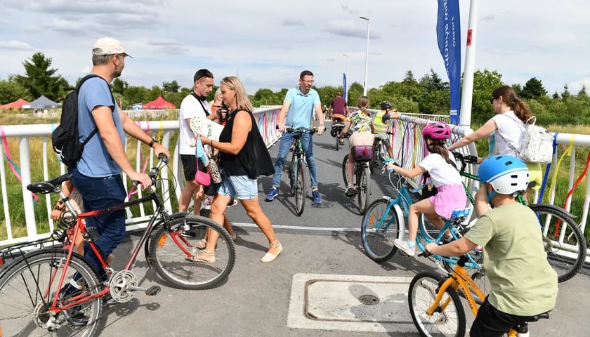 Rowerzyści jadący przez kładkę nad Ślęzą, oddaną do użytku w lipcu br., łączącą Muchobór Wielkim i Muchobór Małym,