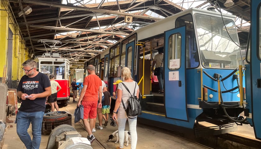Zajezdnia Popowice. Z prawej niebieski tramwaj, obok grupa zwiedzających 