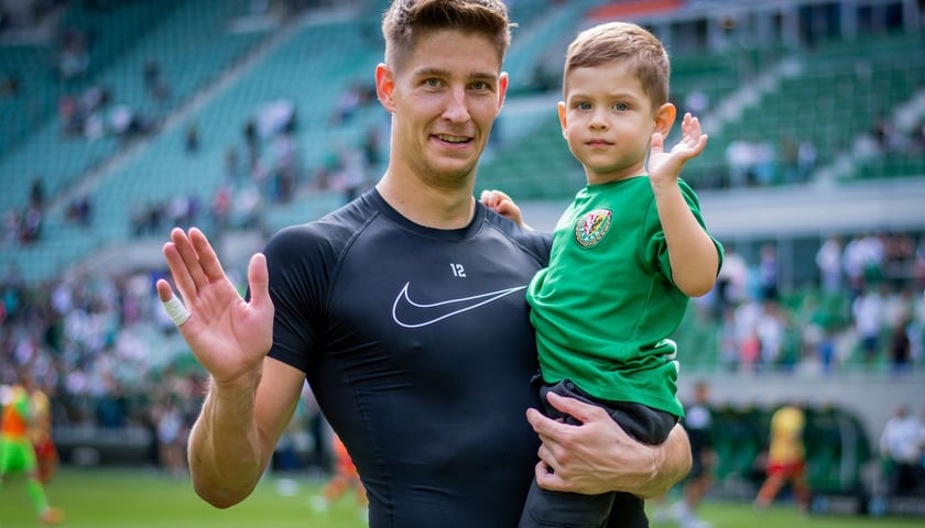 Mężczyzna dzieckiem machają do obiektywu - akcja Dzieci na Stadionie