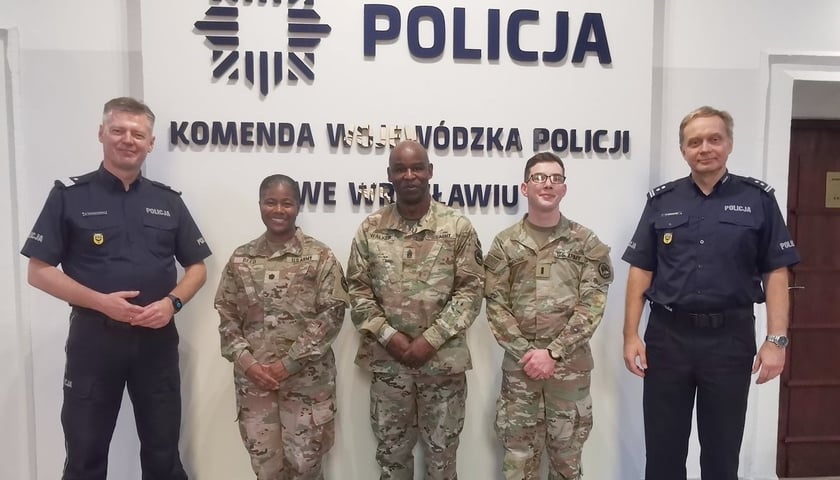 Mężczyźni w mundurach policji i żandarmerii wojskowej USA. Komendant Wojewódzki oraz naczelnik w towarzystwie reprezentacji policji z USA.