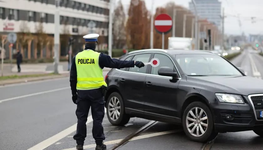 Zdjęcie ilustracyjne. Na zdjęciu policjant kierujący  ruchem na ulicy
