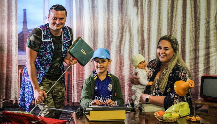 Mama, tata i dziecko w pokoju stylizowanym na lata 80. podczas rodzinnego pikniku w Centrum Historii Zajezdnia 